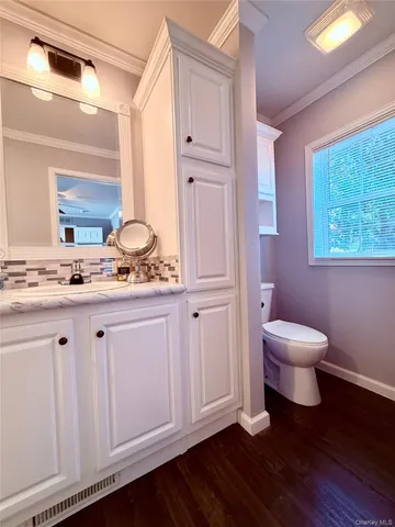a bathroom with a granite countertop sink toilet and mirror