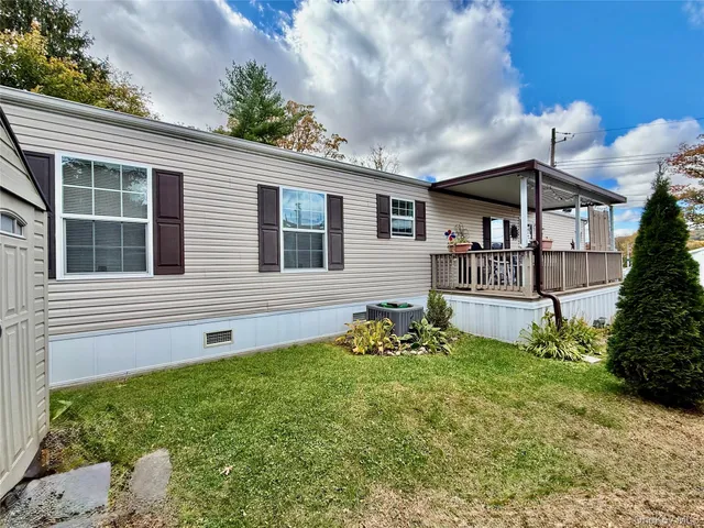 a view of a house with a small yard and potted plants