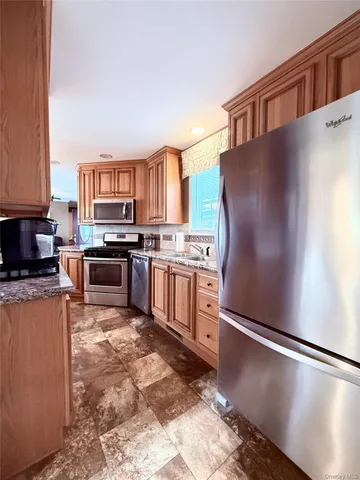a kitchen with stainless steel appliances granite countertop a refrigerator stove top oven a sink and dishwasher