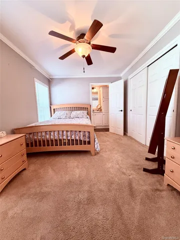 a spacious bedroom with a bed and a ceiling fan