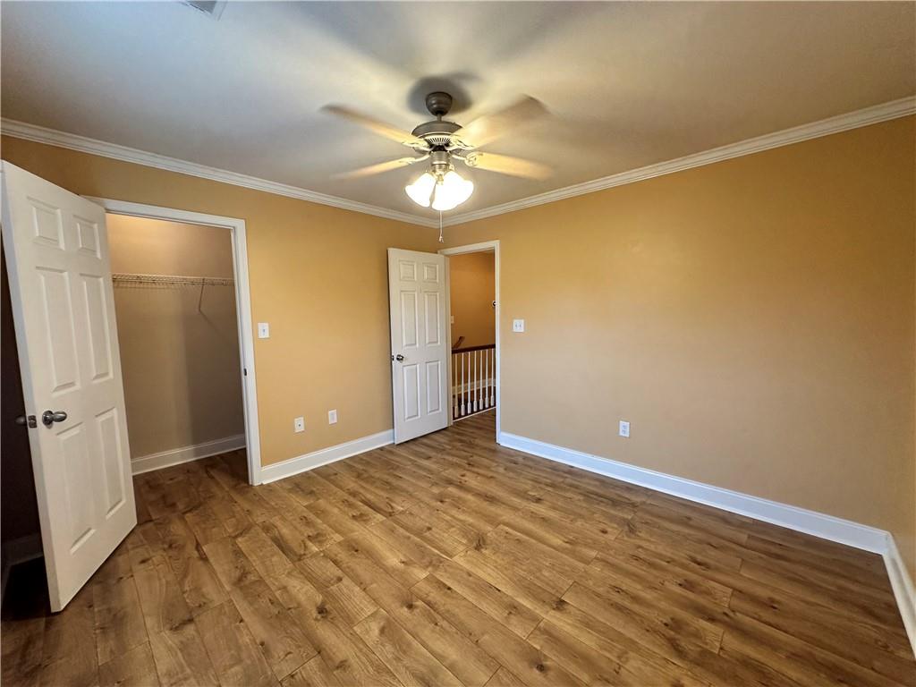 105 Whitehead Road, Unit 10 Athens, GA 30606 - Photo 13 of 16 a view of an empty room with wooden floor and a ceiling fan