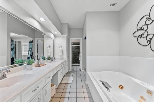a bathroom with a tub sink and mirror