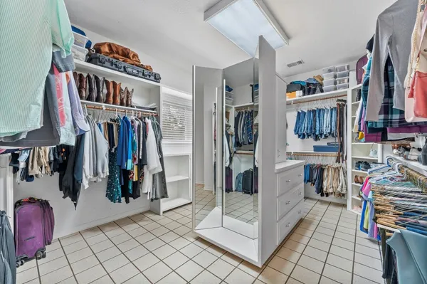 a view of walk in closet with clothes and shoes