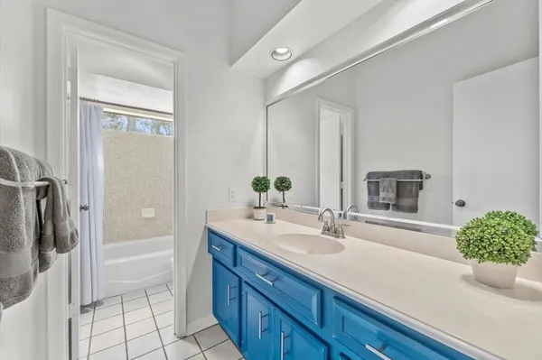 a bathroom with a granite countertop sink a mirror and shower