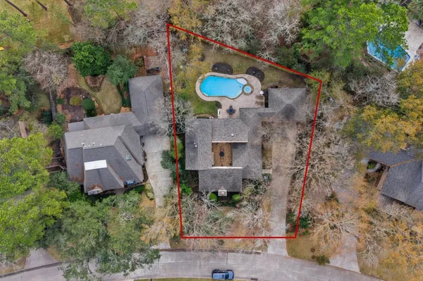 an aerial view of a house with a yard and a large tree