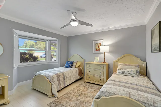 a room with lots of tables a large window and chairs