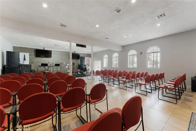 a living room with lots of chairs and a dining table with wooden floor