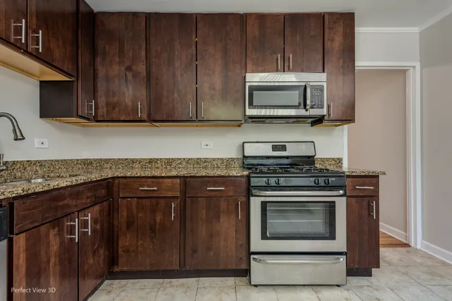 a kitchen with granite countertop wood cabinets and stainless steel appliances