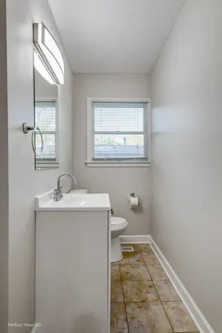 a bathroom with a sink toilet and window