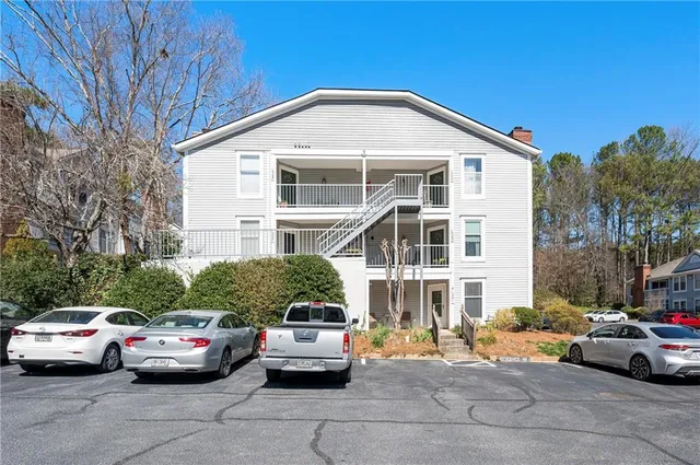a front view of a house with cars parked on road