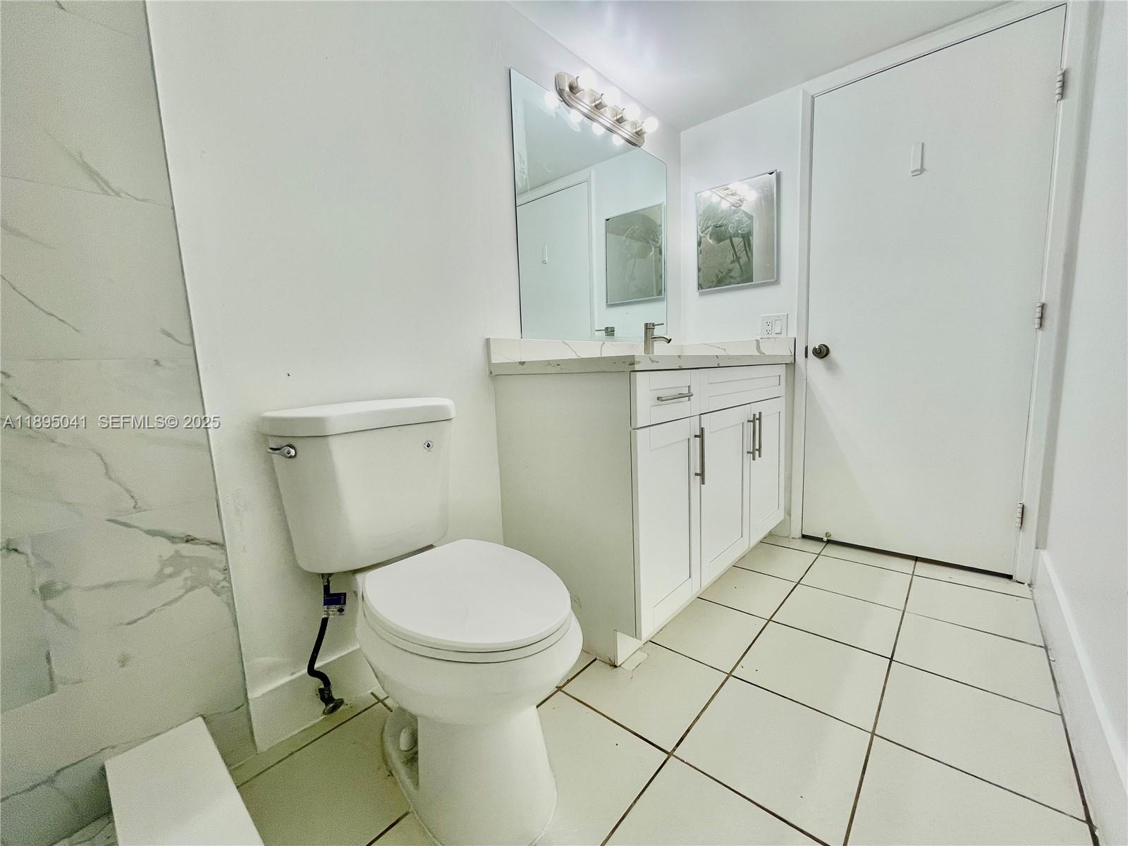 2209 South Cypress Bend Drive, Unit 407 Pompano Beach, FL 33069 - Photo 21 of 53 a bathroom with a toilet a sink and mirror