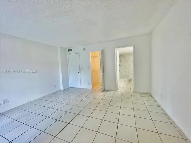a room with gym equipment and wooden floor