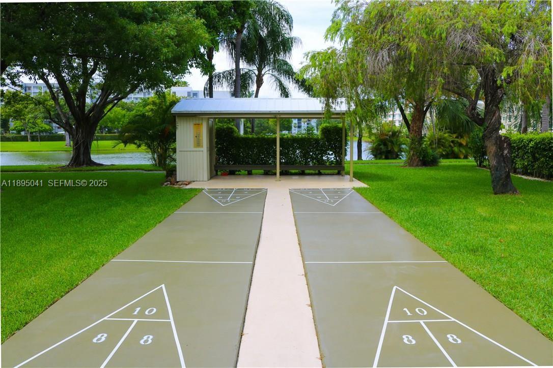 2209 South Cypress Bend Drive, Unit 407 Pompano Beach, FL 33069 - Photo 38 of 53 a view of patio with a table and chairs under an umbrella