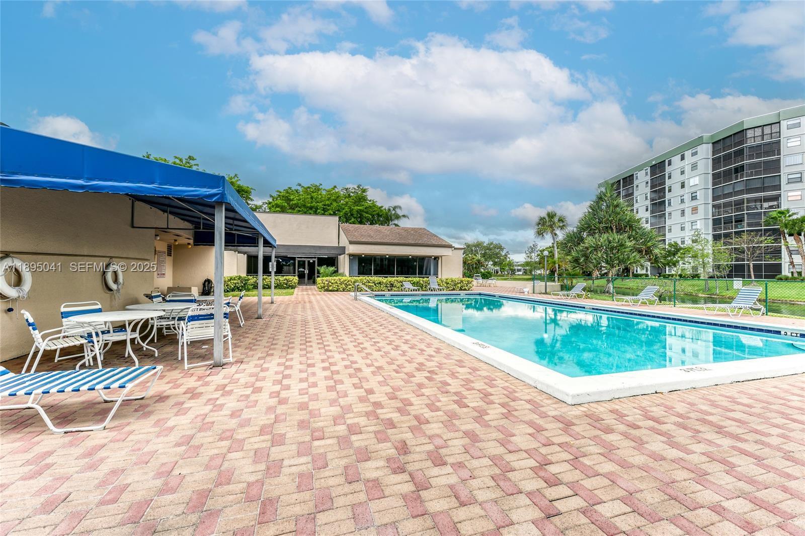 2209 South Cypress Bend Drive, Unit 407 Pompano Beach, FL 33069 - Photo 48 of 53 a view of a swimming pool with a patio