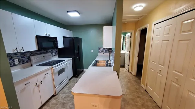 a kitchen with a sink and a stove top oven with wooden floor