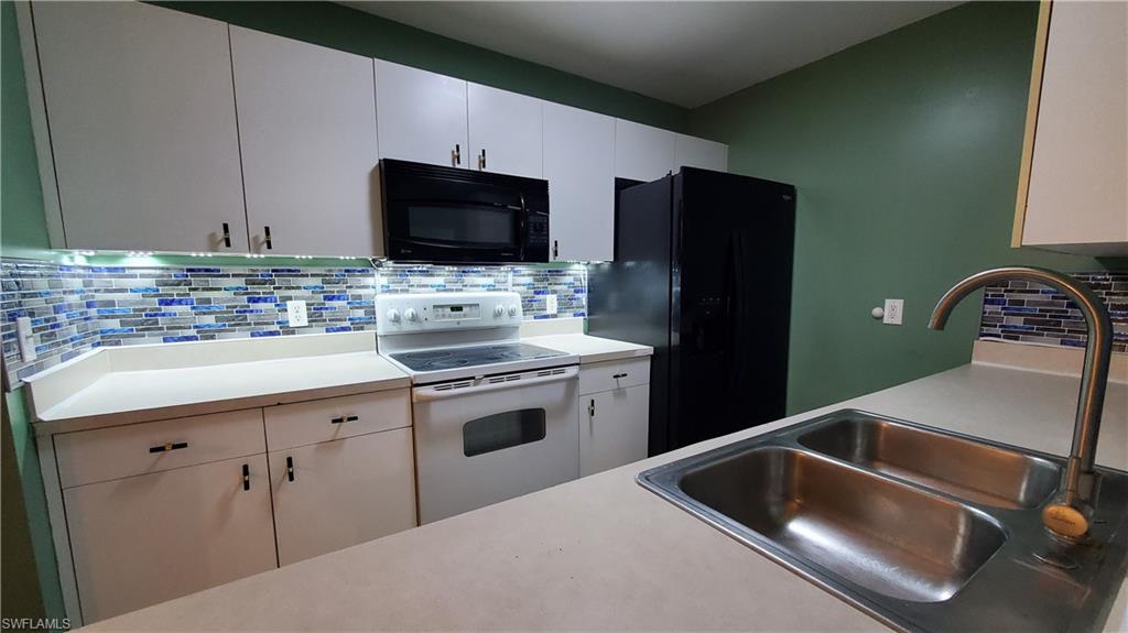 7319 Albany Road Fort Myers, FL 33967 - Photo 12 of 47 a kitchen with a sink and a stove top oven with wooden floor