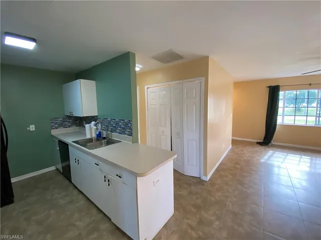 a kitchen with a refrigerator sink and white cabinets