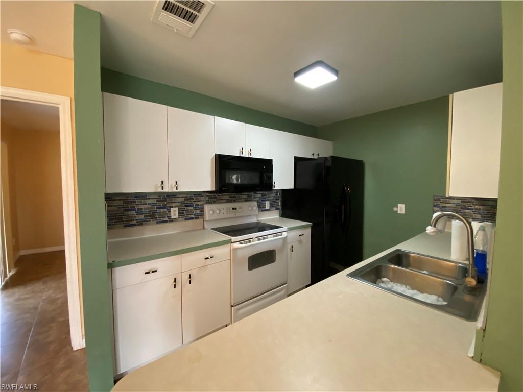 7319 Albany Road Fort Myers, FL 33967 - Photo 6 of 47 a kitchen with a sink a stove top oven and refrigerator