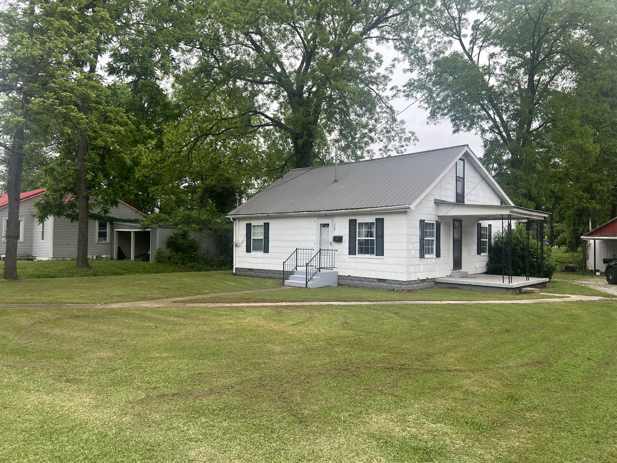 a front view of a house with a garden and trees