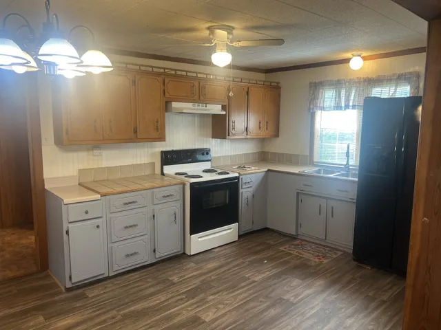 a kitchen with a white cabinets and window