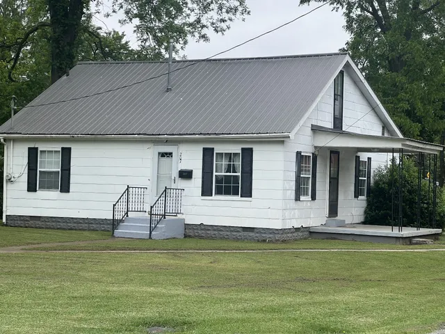 a front view of house with a garden and swimming pool