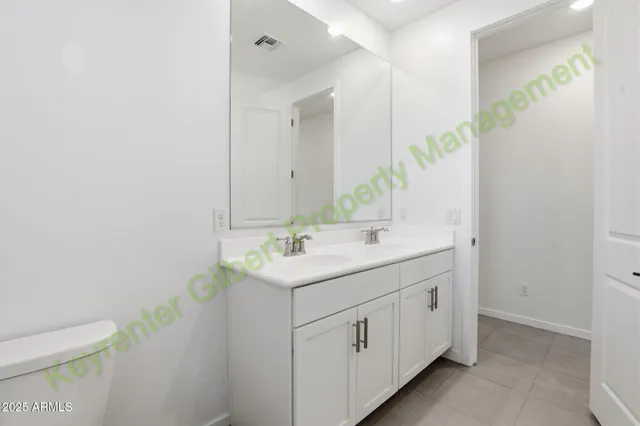 a bathroom with a granite countertop sink a toilet and a mirror
