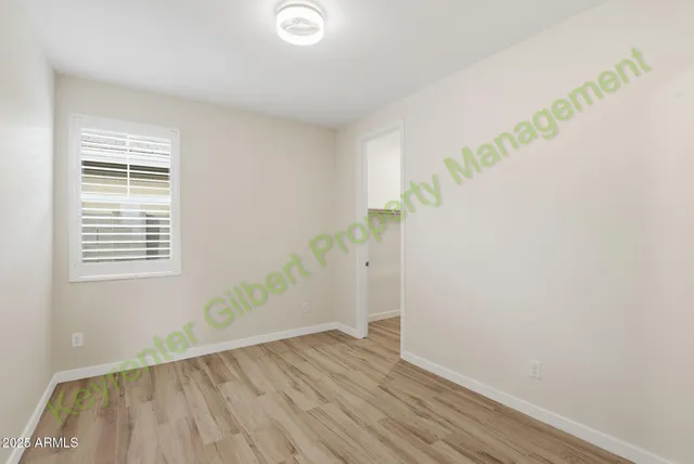an empty room with wooden floor and entrance