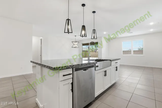 a kitchen with stainless steel appliances granite countertop a refrigerator a sink and a stove