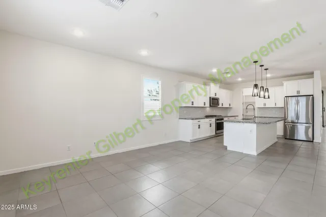 a kitchen with stainless steel appliances granite countertop a sink a stove and a wooden floor