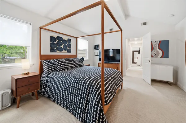 a bedroom with a large bed and a table chair