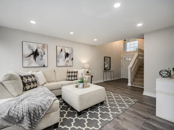 a living room with furniture and wooden floor
