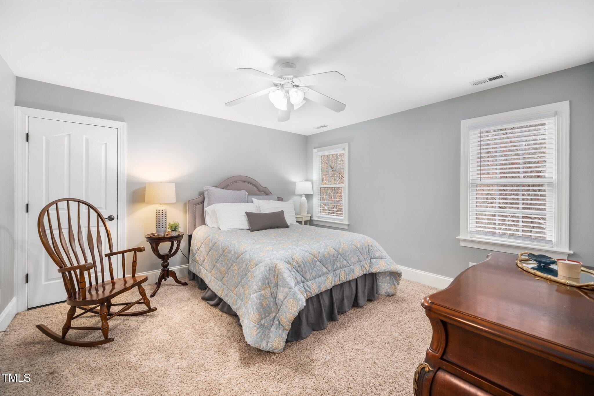 7001 Millstone Ridge Court Raleigh, NC 27614 - Photo 30 of 54 a bedroom with a bed chair and two windows
