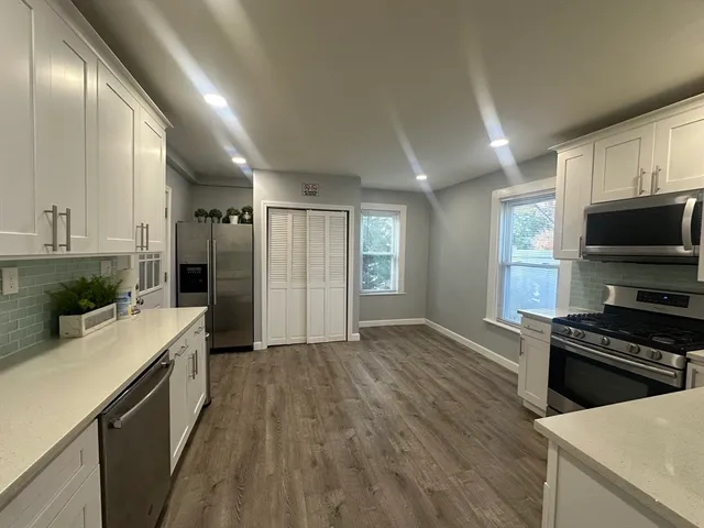 a kitchen with granite countertop a stove and a wooden floors