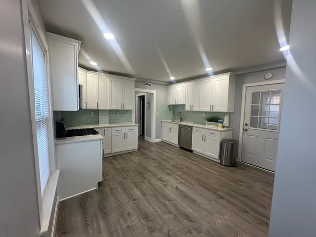 a kitchen with white cabinets and stainless steel appliances