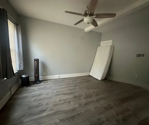 a view of a livingroom with wooden floor and a ceiling fan