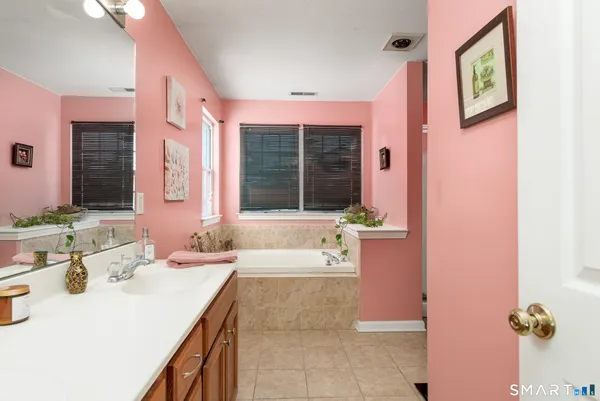 a bathroom with a tub sink and mirror