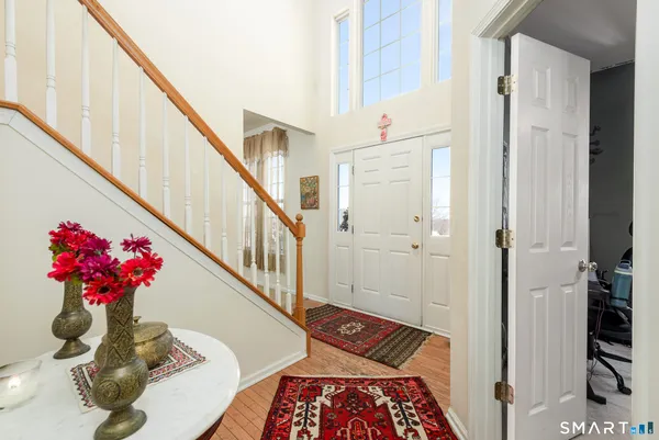 a view of a hallway with wooden floor and stairs