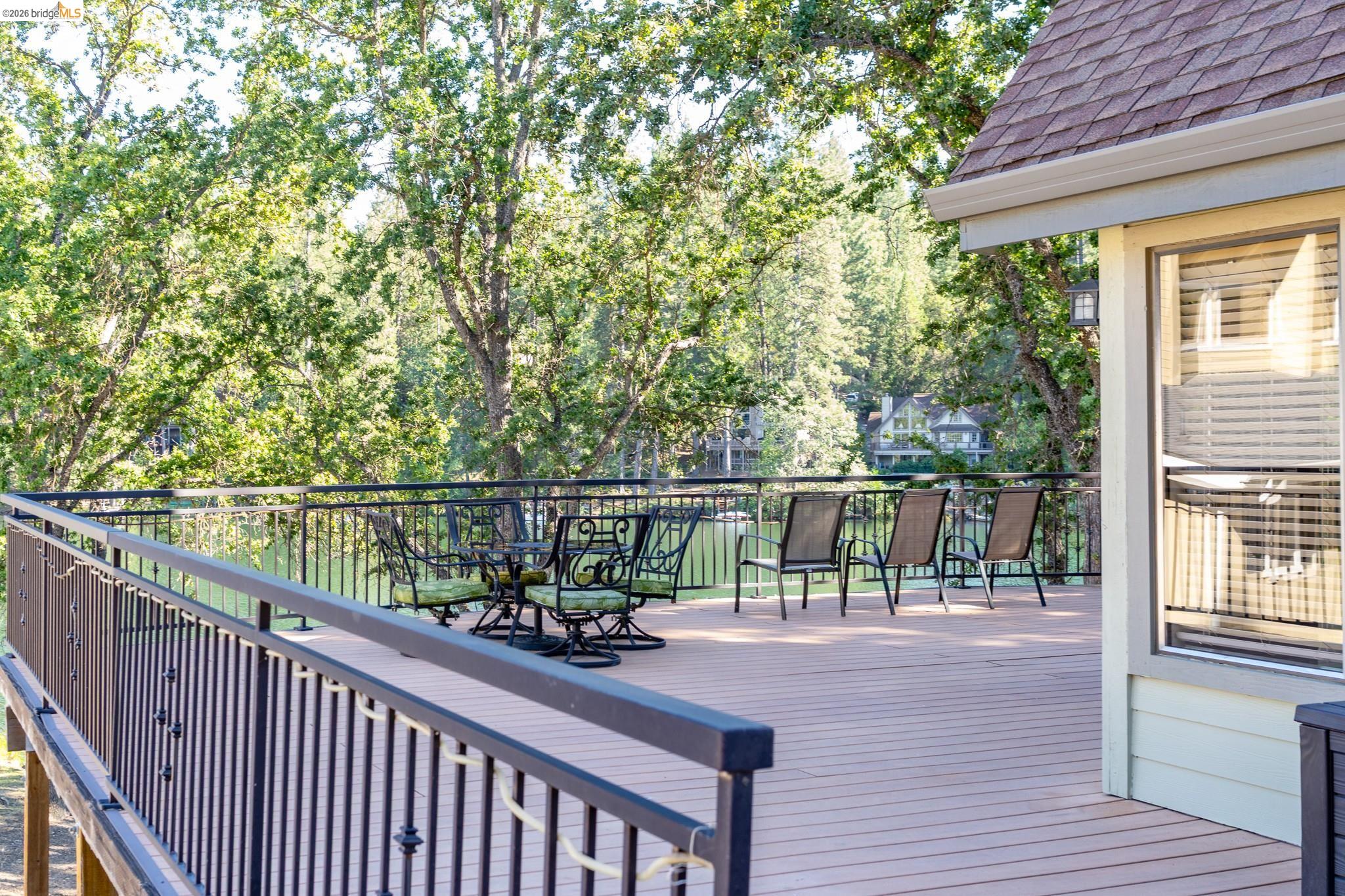 19711 Pleasantview Drive Groveland, CA 95321 - Photo 9 of 39 Expansive outdoor deck featuring wood-finish flooring, black metal railings, and a partial exterior wall with horizontal siding
