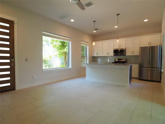 a kitchen with stainless steel appliances a refrigerator sink and microwave