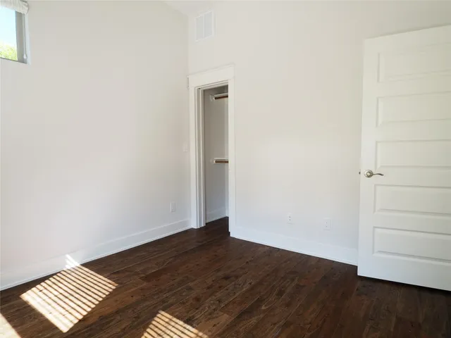an empty room with wooden floor and closet
