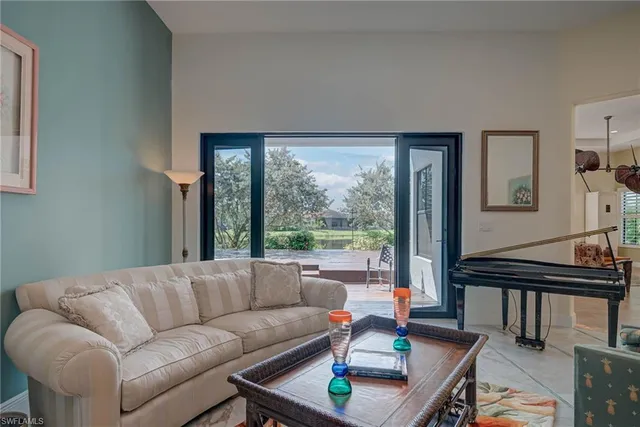 a living room with furniture a flat screen tv and kitchen view