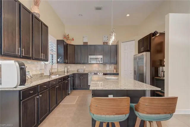 a kitchen with stainless steel appliances granite countertop wooden cabinets a sink and dishwasher