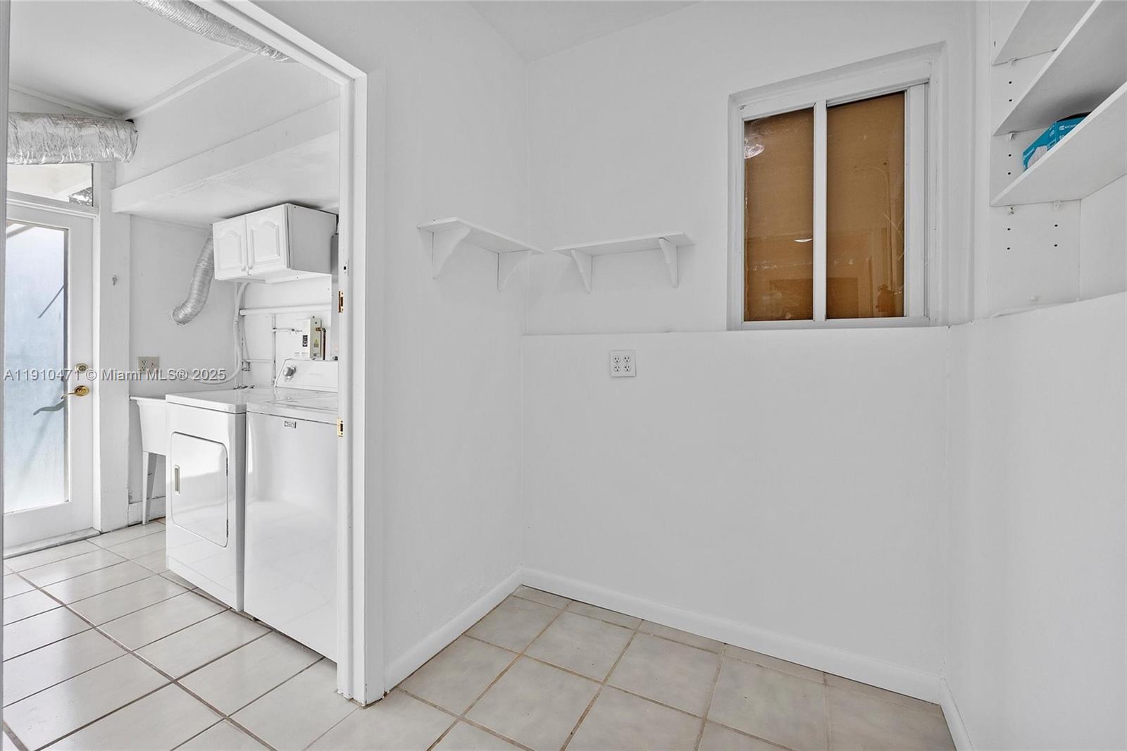 11111 Southwest 78th Court Pinecrest, FL 33156 - Photo 13 of 36 a view of a kitchen with white cabinets and a refrigerator