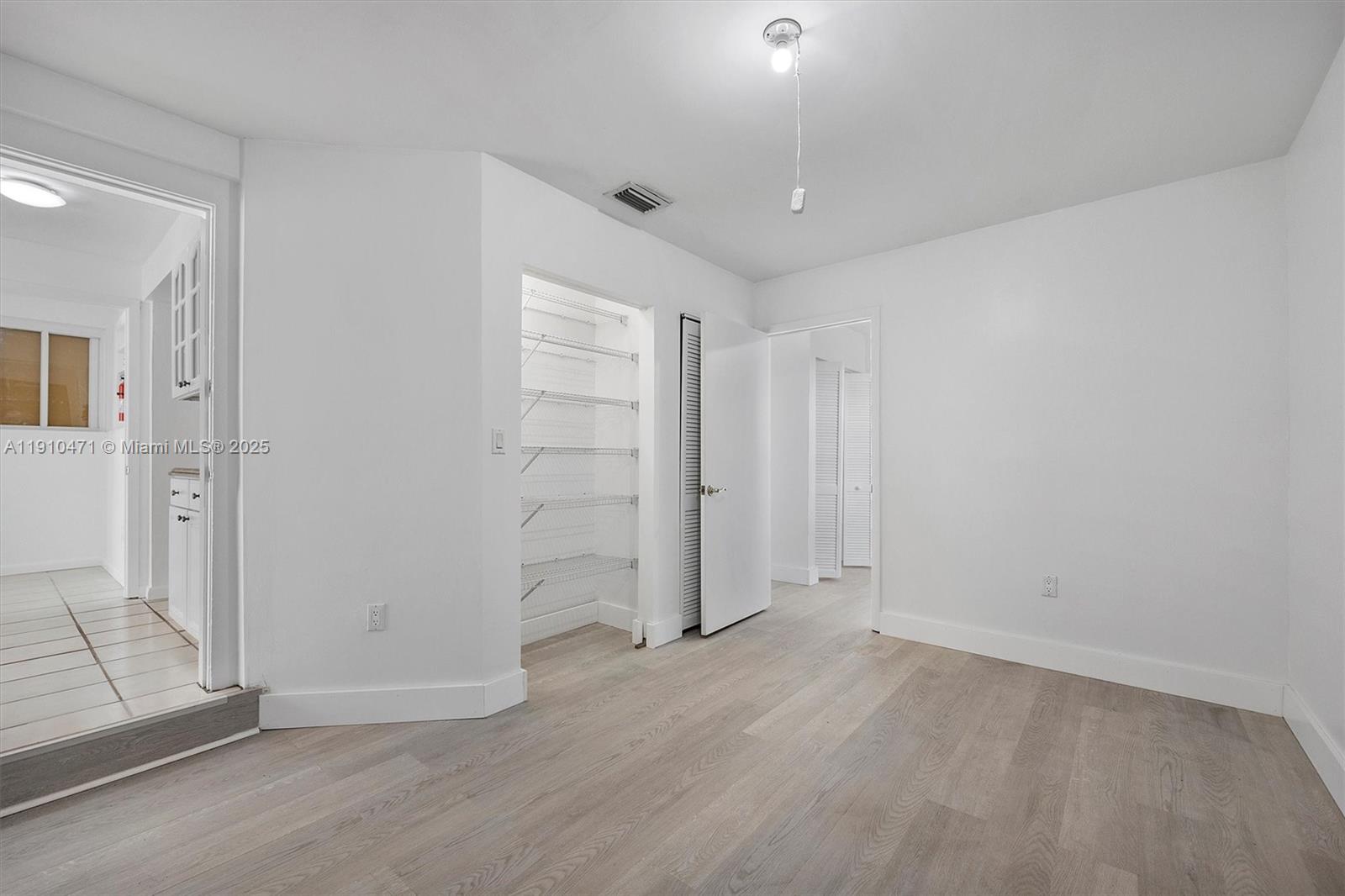 11111 Southwest 78th Court Pinecrest, FL 33156 - Photo 15 of 36 wooden floor in an empty room with a window