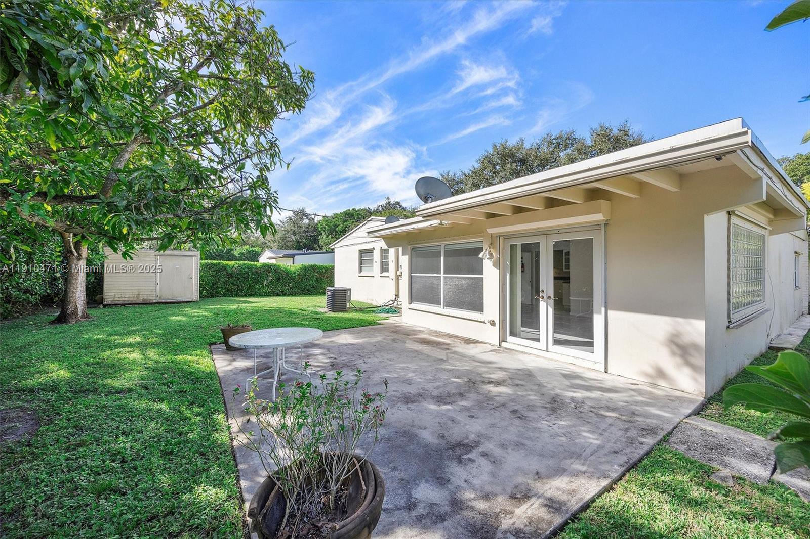 11111 Southwest 78th Court Pinecrest, FL 33156 - Photo 27 of 36 a view of a house with backyard and a garden