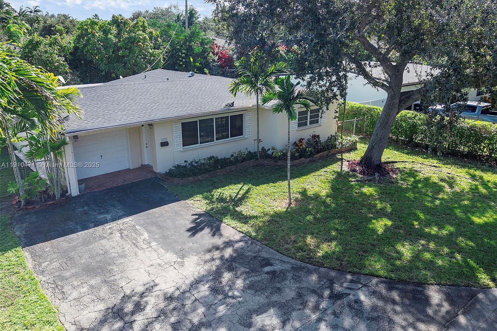 11111 Southwest 78th Court Pinecrest, FL 33156 - Photo 29 of 36 a house that has a tree in front of it