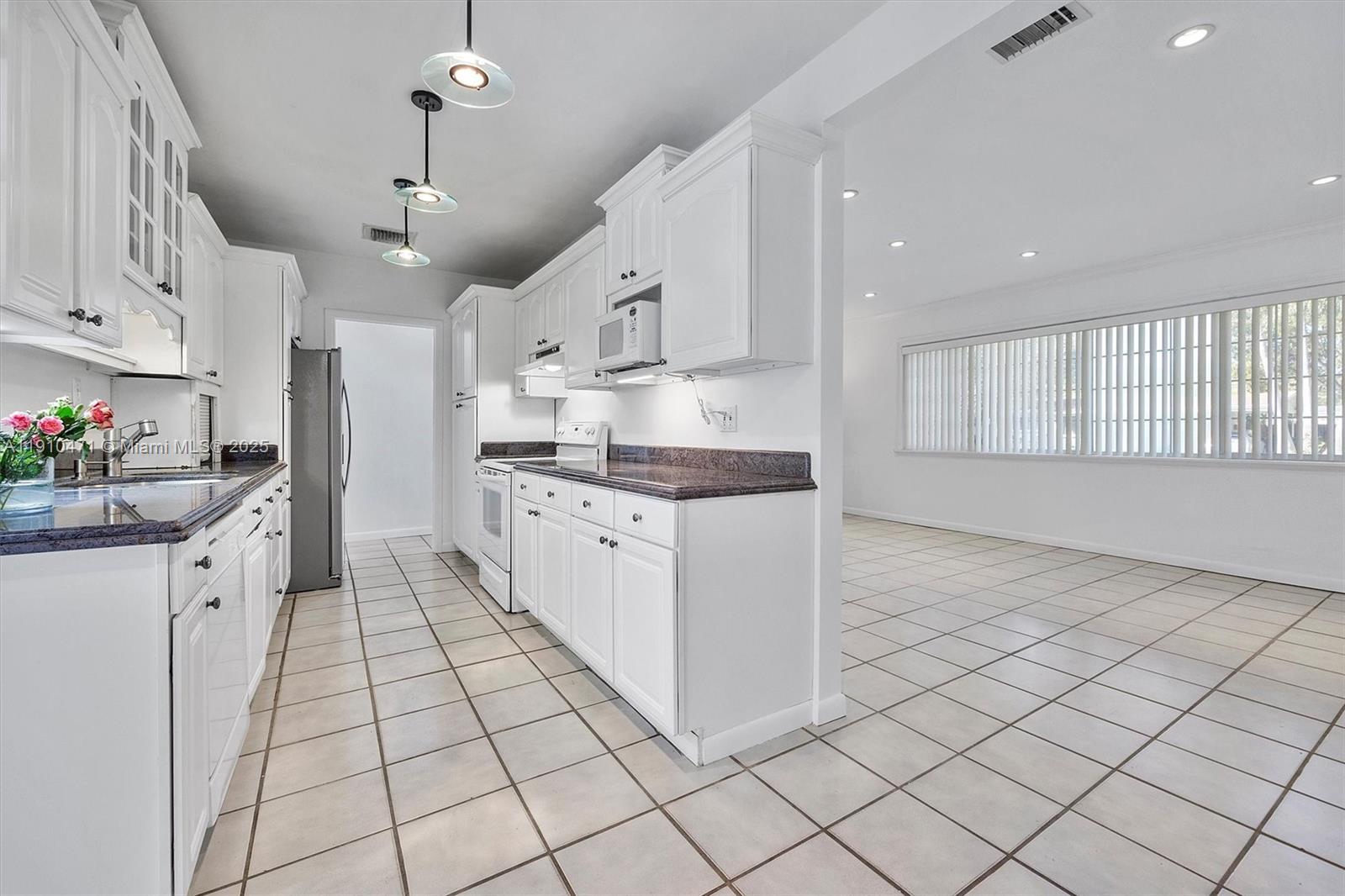 11111 Southwest 78th Court Pinecrest, FL 33156 - Photo 6 of 36 a kitchen with stainless steel appliances kitchen island granite countertop a sink and cabinets