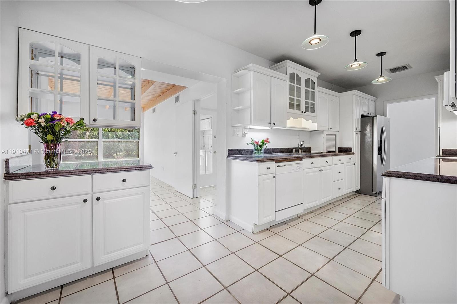 11111 Southwest 78th Court Pinecrest, FL 33156 - Photo 7 of 36 a kitchen with stainless steel appliances kitchen island granite countertop a refrigerator a sink dishwasher and white cabinets with wooden floor