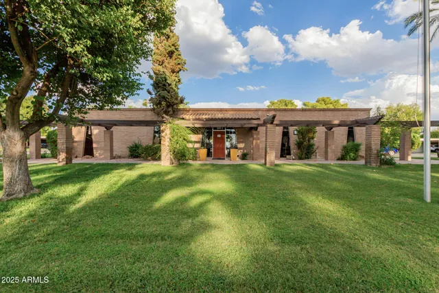 a view of a tennis ground with large trees
