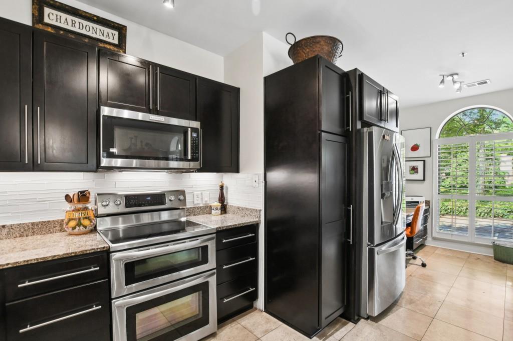 2921 Lenox Road Northeast, Unit 103 Atlanta, GA 30324 - Photo 14 of 37 a kitchen with stainless steel appliances granite countertop a refrigerator and a stove